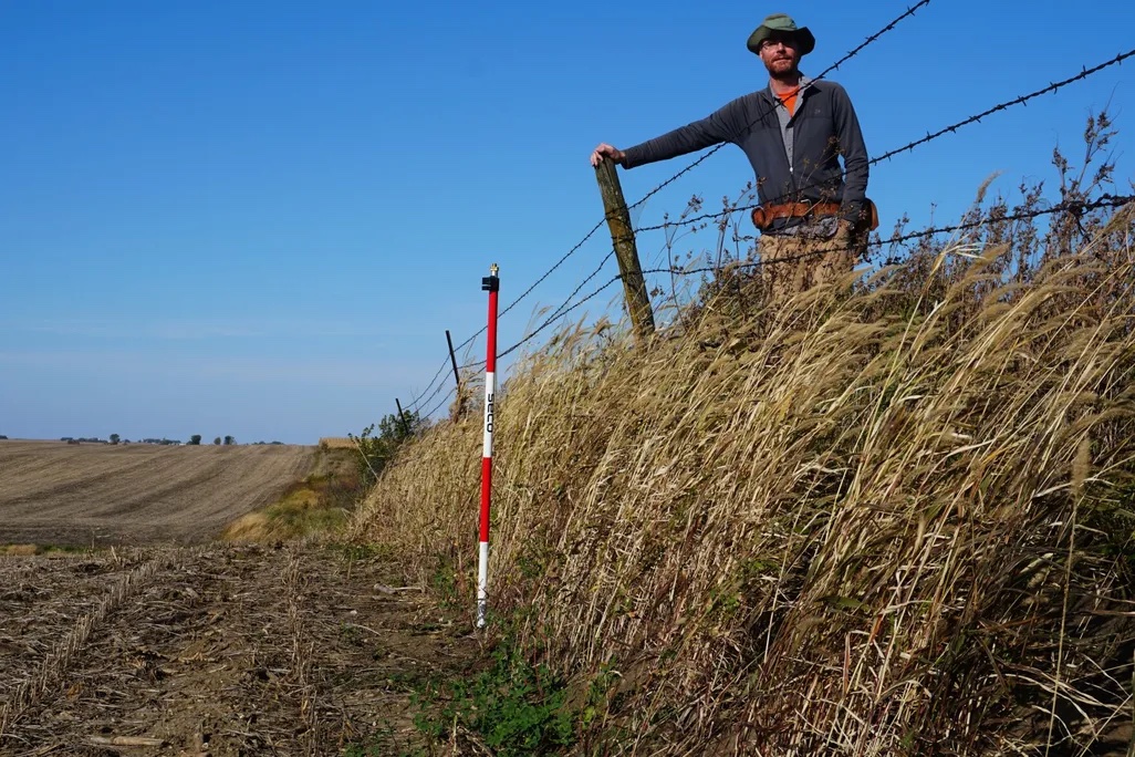 UMass Amherst geosciences professor Isaac Larsen standing on the erosional escarpment at Stinson Prairie, Iowa. Credit: UMass Amherst